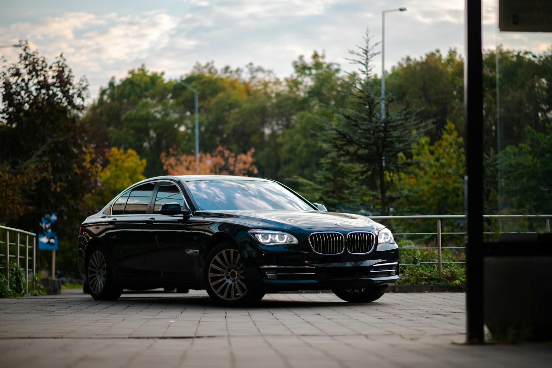 Czarny Rolls-Royce sedan zaparkowany na tle zieleni w słoneczny dzień Czarny Rolls-Royce sedan zaparkowany na tle zieleni w słoneczny dzień