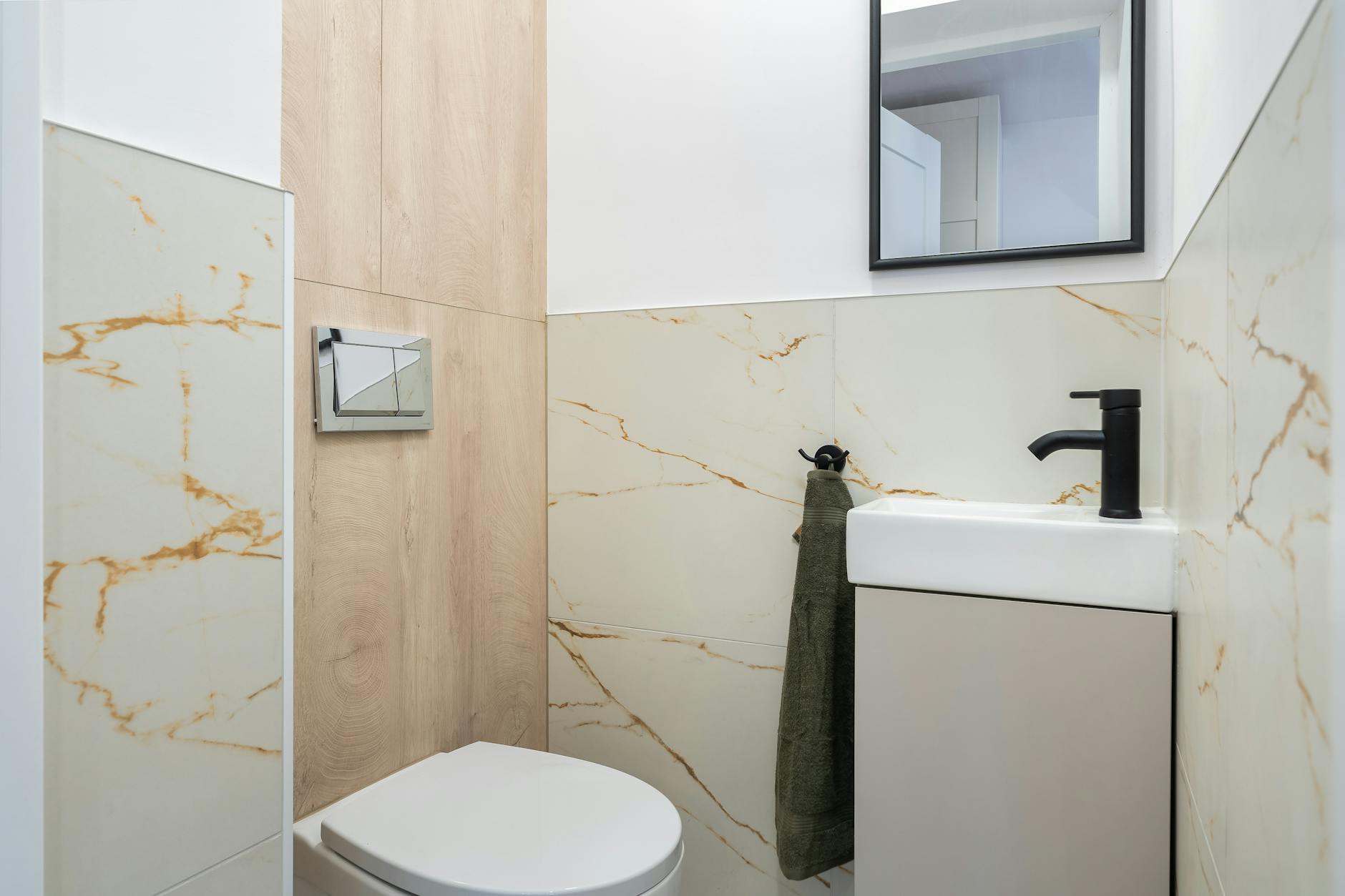 Mała nowoczesna łazienka z marmurowymi płytkami i kompaktową umywalką