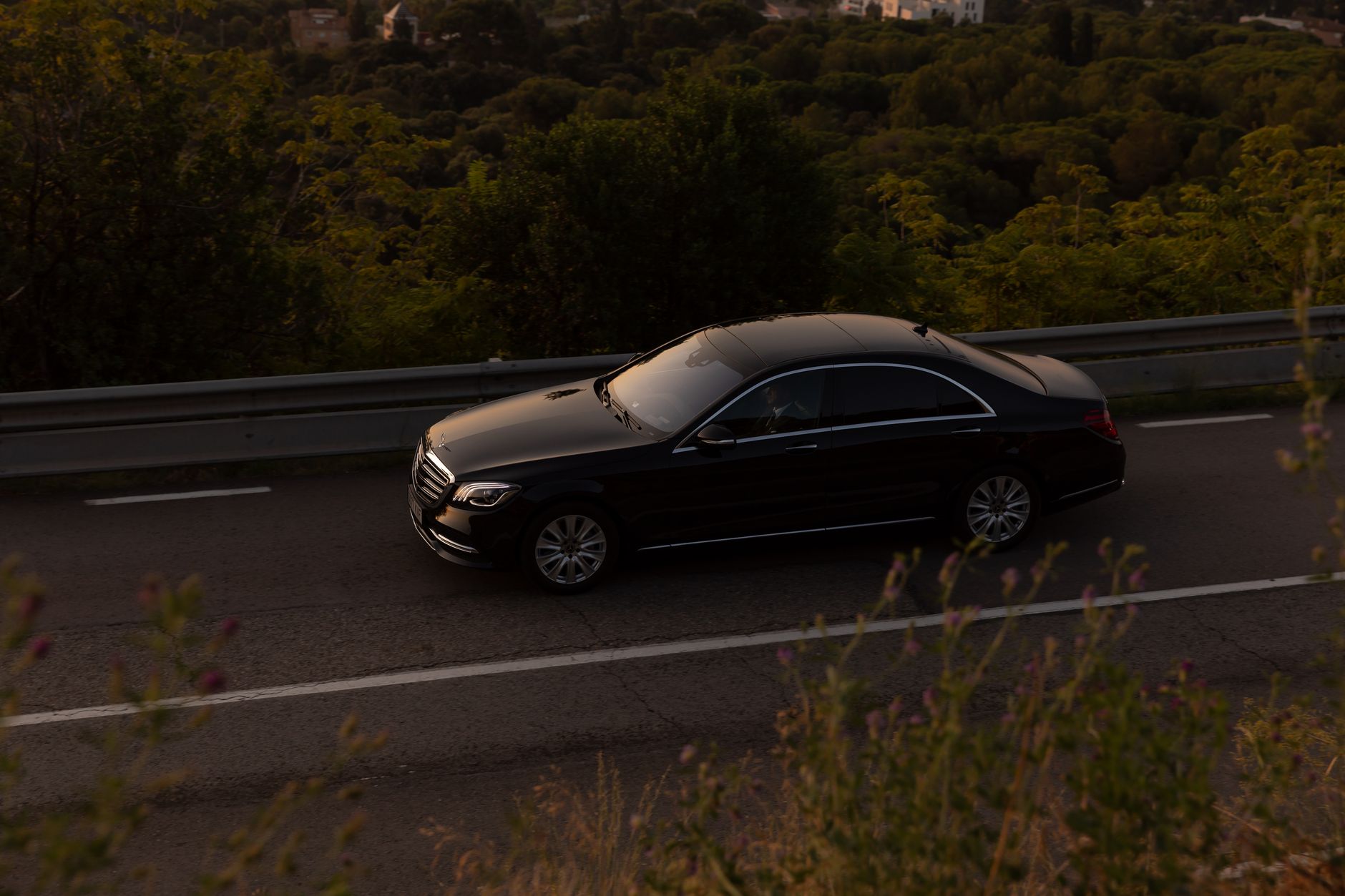 Czarne luksusowe Maserati jedzie leśną drogą za dnia